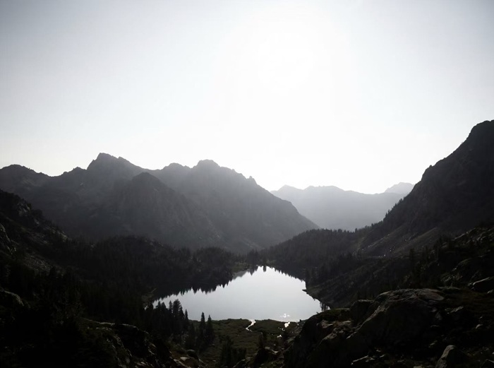 Backlit mountain lake with hazy contrast, the original photo
